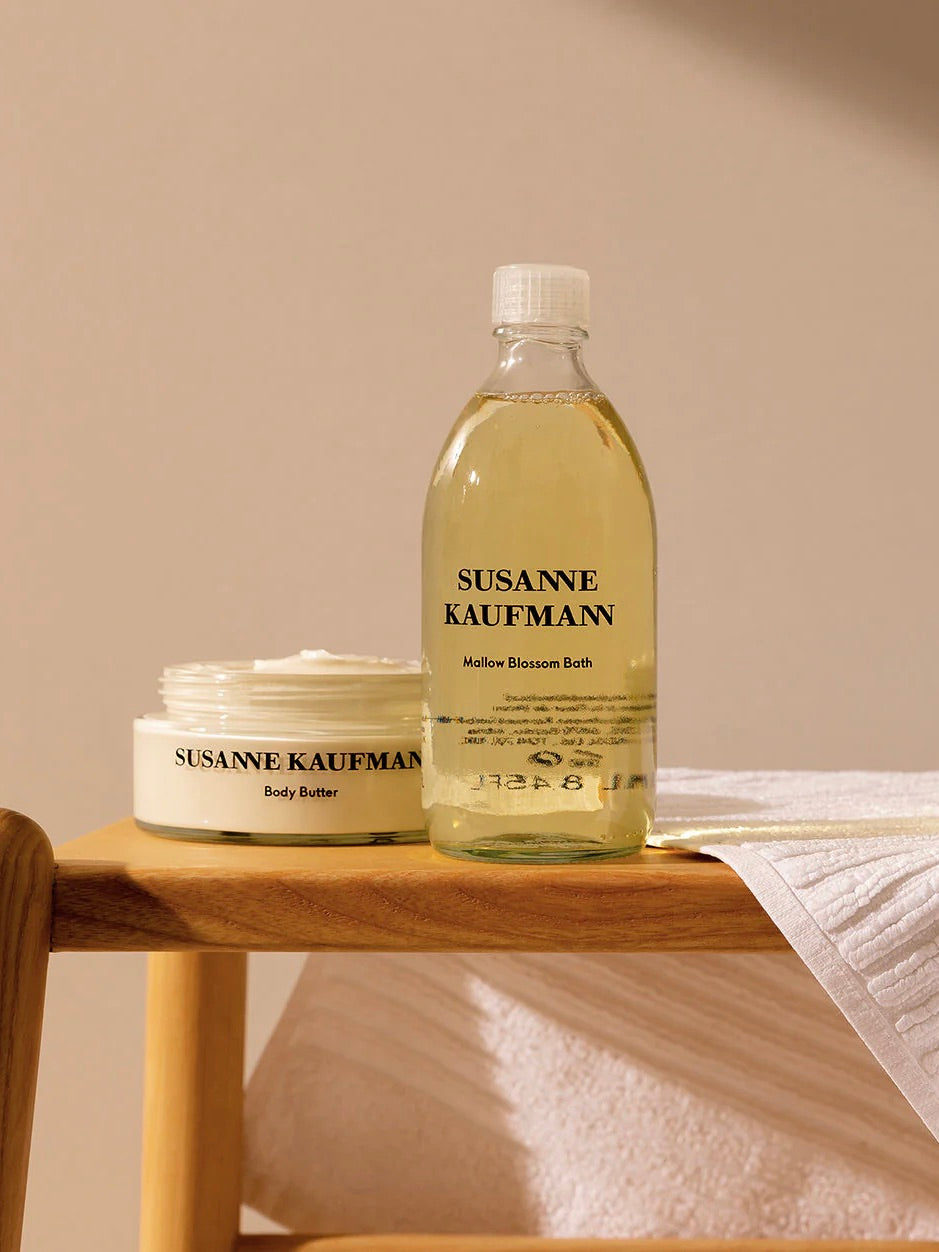 Susanne Kaufmann body butter and bath product on a wooden shelf with a beige background