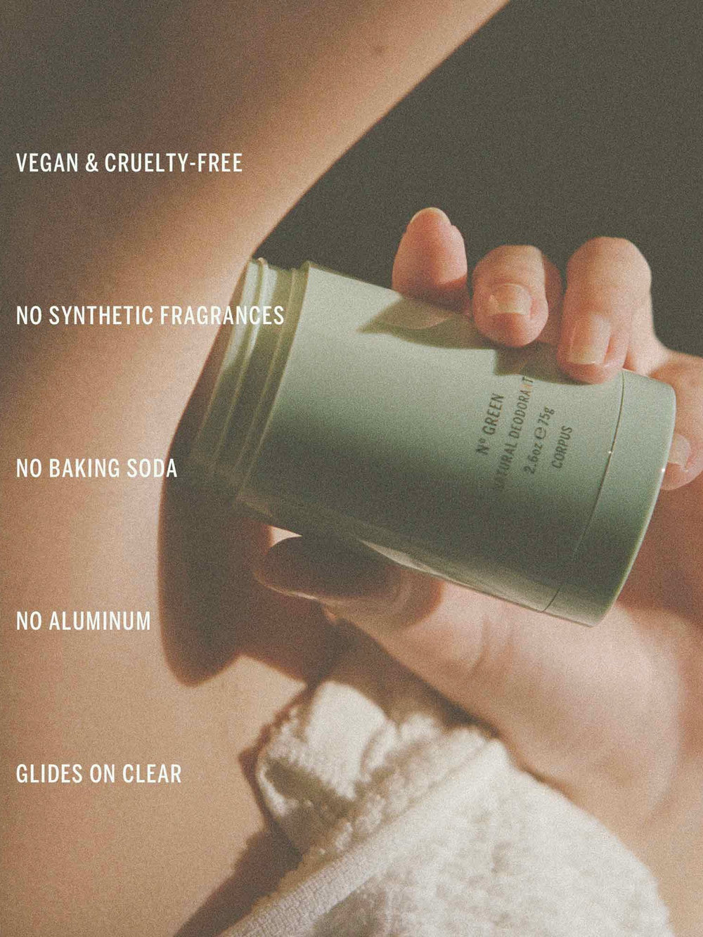 Hand holding a green skincare product container with text highlighting vegan, cruelty-free, and synthetic fragrance-free qualities.
