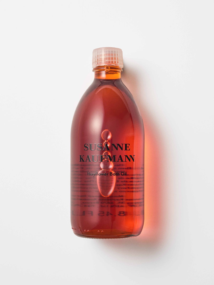 Bottle of Susanne Kaufmann bath oil on a white background