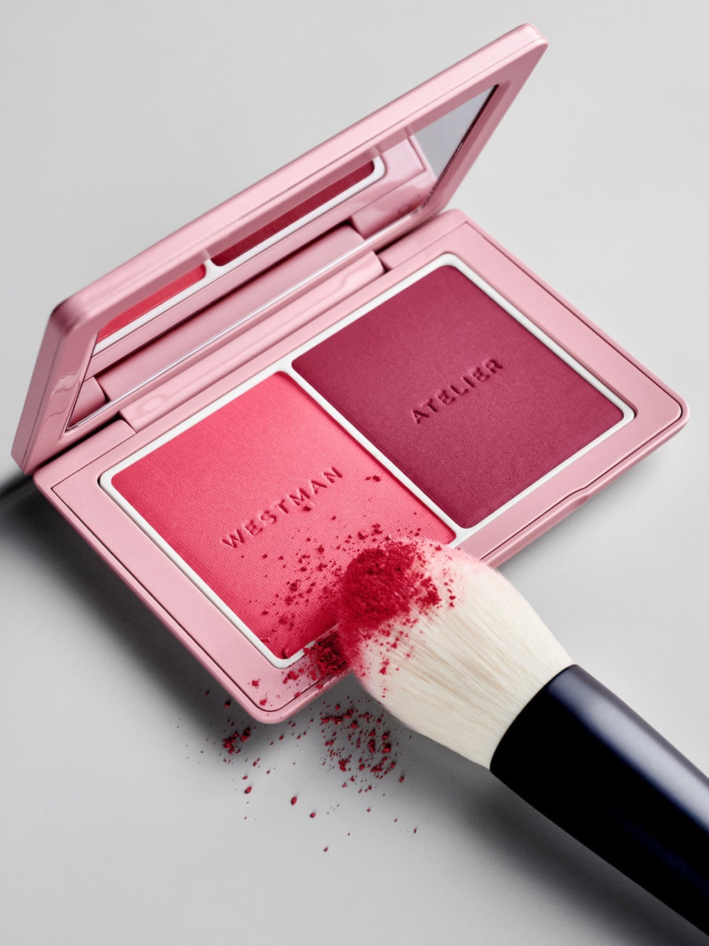 Westman Atelier blush palette with a brush on a gray background
