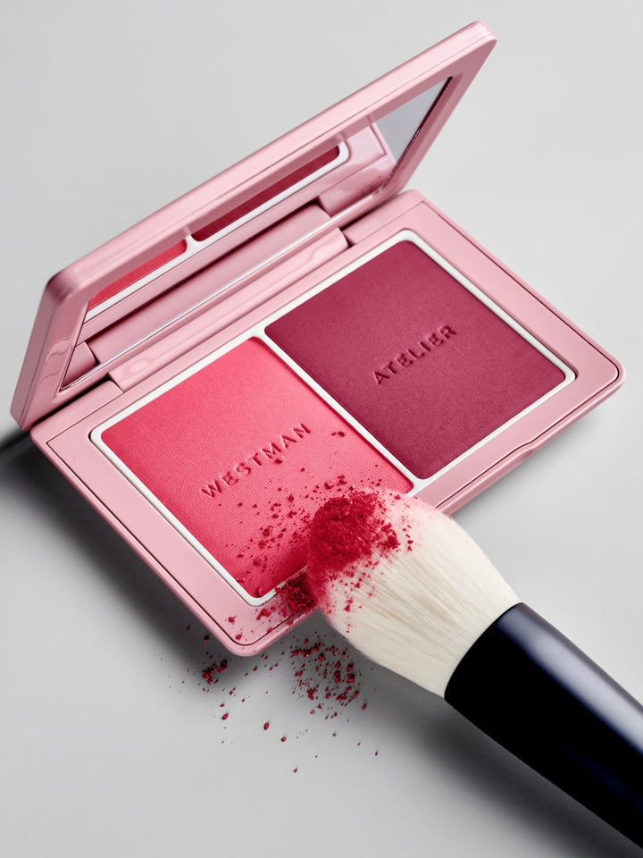 Westman Atelier blush palette with a brush on a gray background