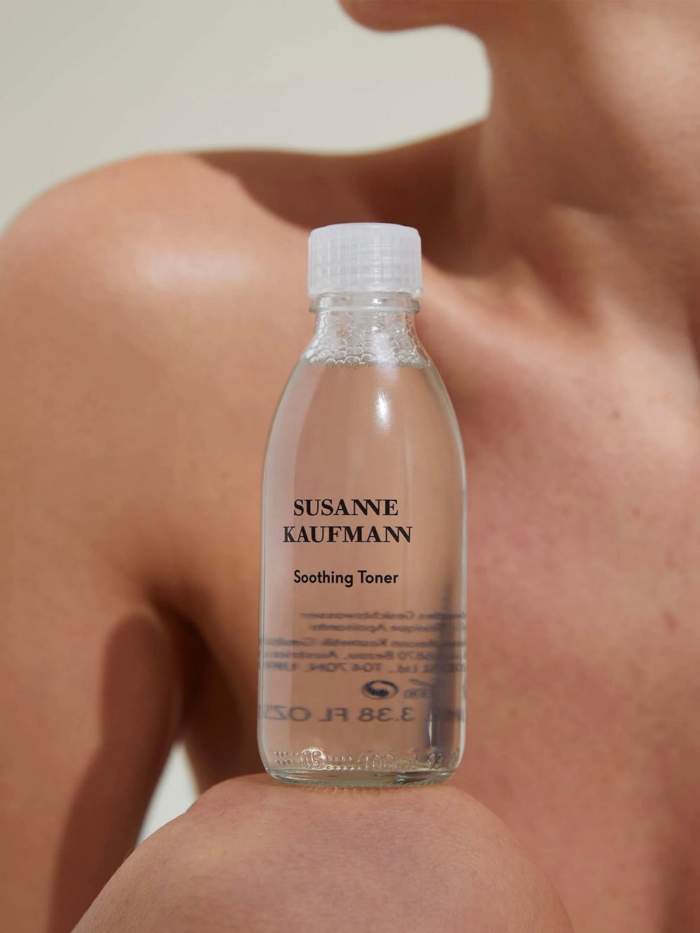 Bottle of Susanne Kaufmann Soothing Toner held against a blurred background
