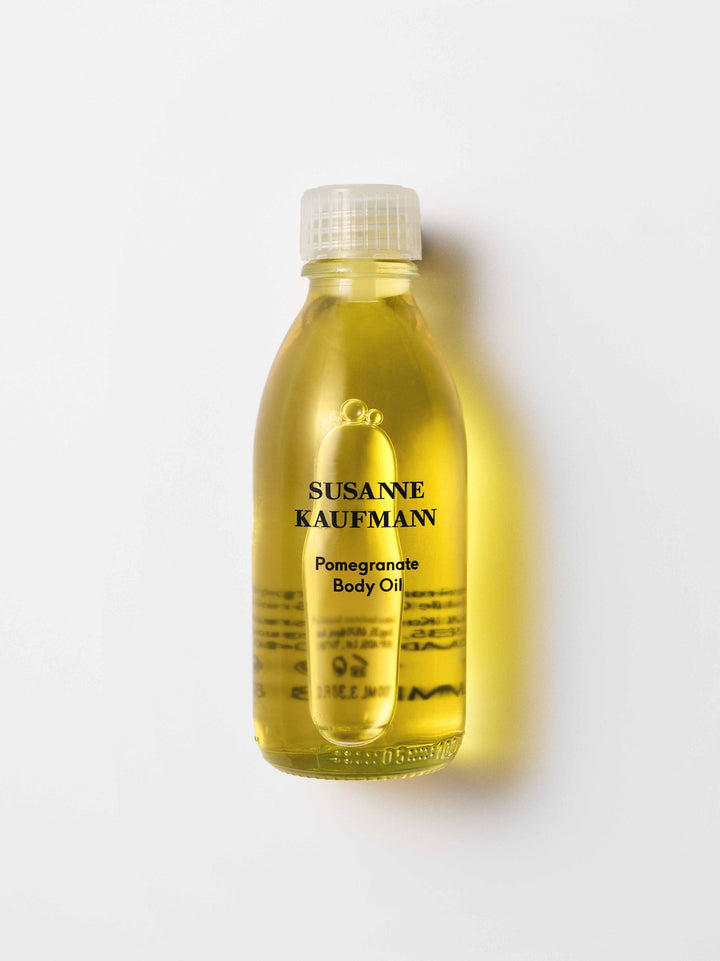 Bottle of Susanne Kaufman Pomegranate Body Oil on a white background