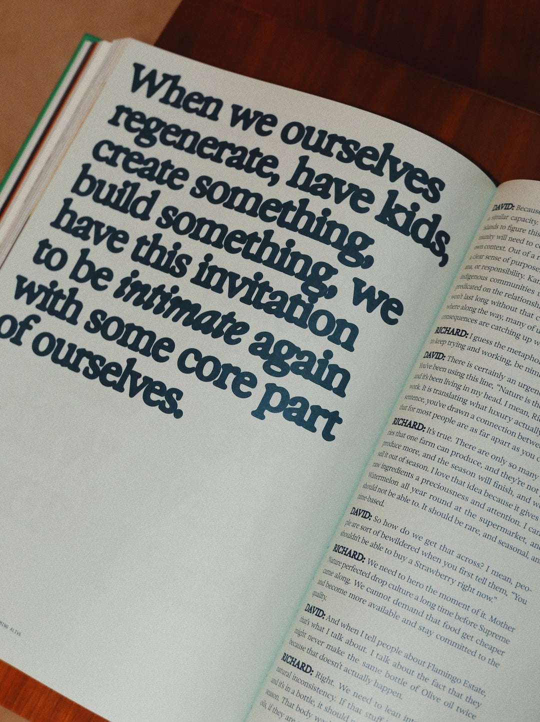 Open book with text on a wooden surface; The Guide to Becoming Alive
