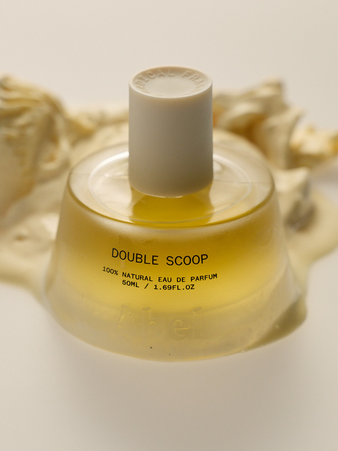 Perfume bottle labeled 'Double Scoop' on a neutral background