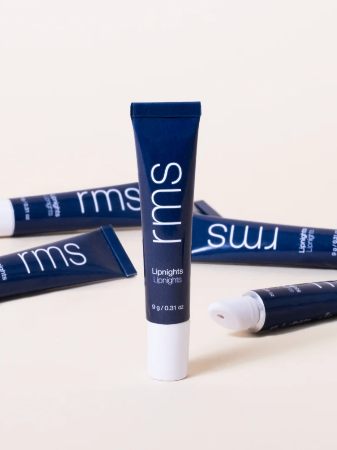 Blue cosmetic tubes with 'rms' branding on a white background